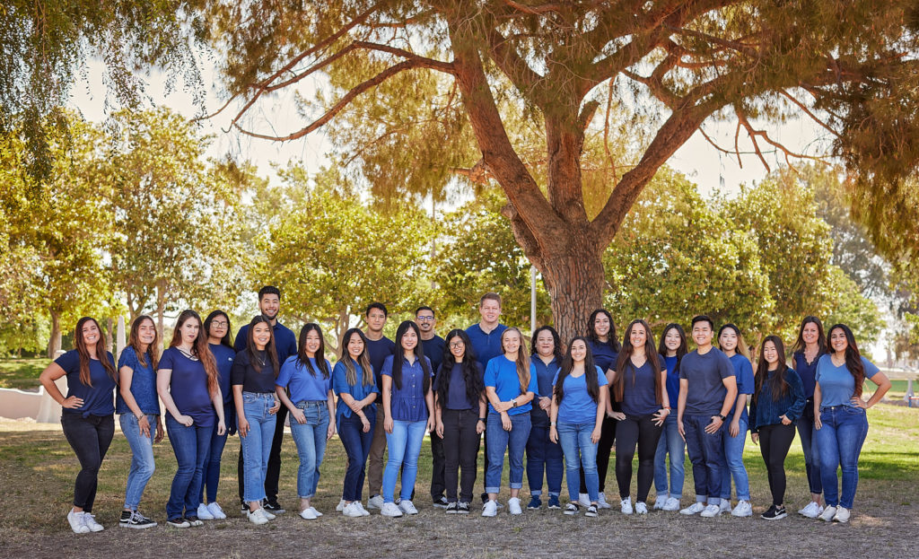 The team at Spectrum Behavioral Therapies poses outside under trees for a group photo