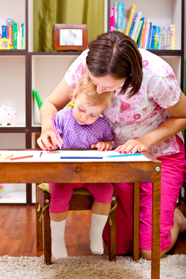 Mother helping her daughter to draw