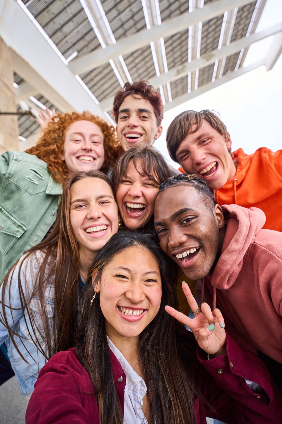 A group photo of young people smiling outside