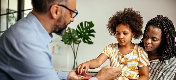 Child with parent and therapist during session