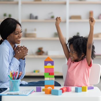 A black young girl and young woman play together as they learn